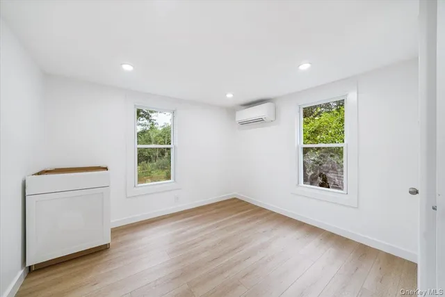 an empty room with wooden floor and a window