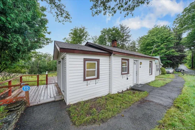 a view of a small house with a yard