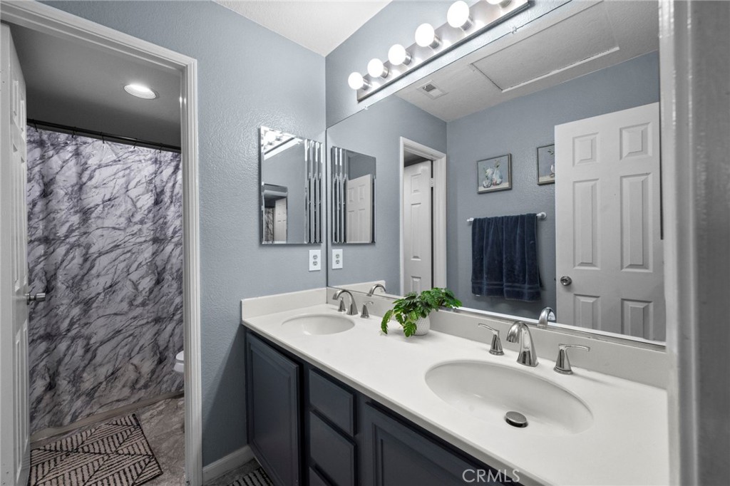 3684 North Veronica Court Rialto, CA 92377 - Photo 12 of 75 a bathroom with double vanity sinks and a mirror