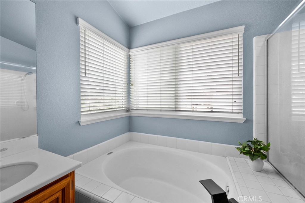 3684 North Veronica Court Rialto, CA 92377 - Photo 22 of 75 a white bath tub sitting in a bathroom next to a window