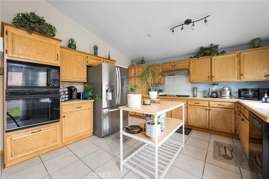 3684 North Veronica Court Rialto, CA 92377 - Photo 41 of 75 a kitchen with a sink cabinets and stainless steel appliances