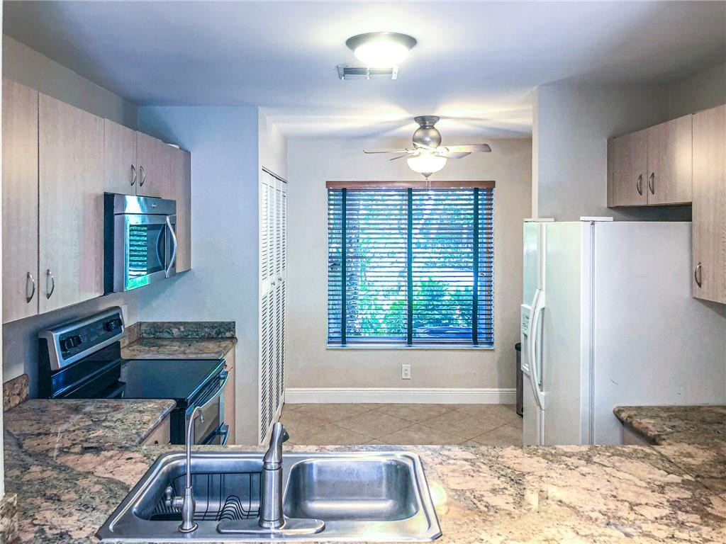 2000 Riverside Place, Unit 4 Wilton Manors, FL 33305 - Photo 3 of 40 a kitchen with kitchen island granite countertop a refrigerator and a sink