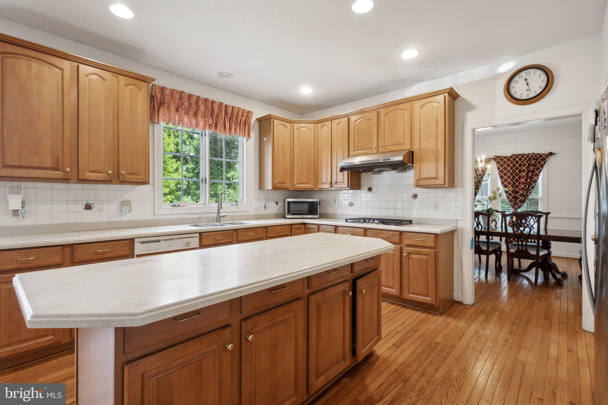 7102 Clarkson Drive Springfield, VA 22150 - Photo 5 of 26 a kitchen with stainless steel appliances granite countertop a sink a stove cabinets counter space and a window