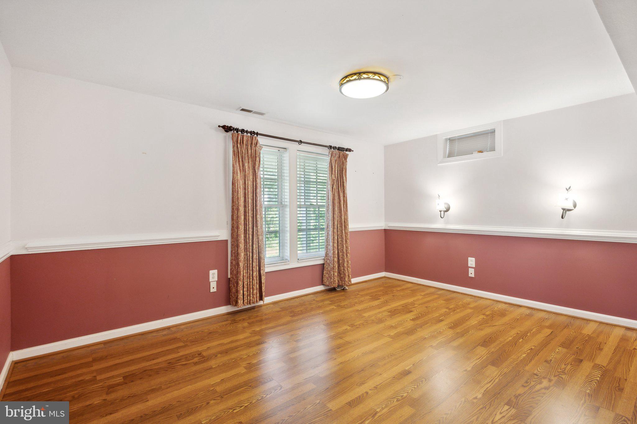 7102 Clarkson Drive Springfield, VA 22150 - Photo 7 of 26 a view of an empty room with wooden floor and a window