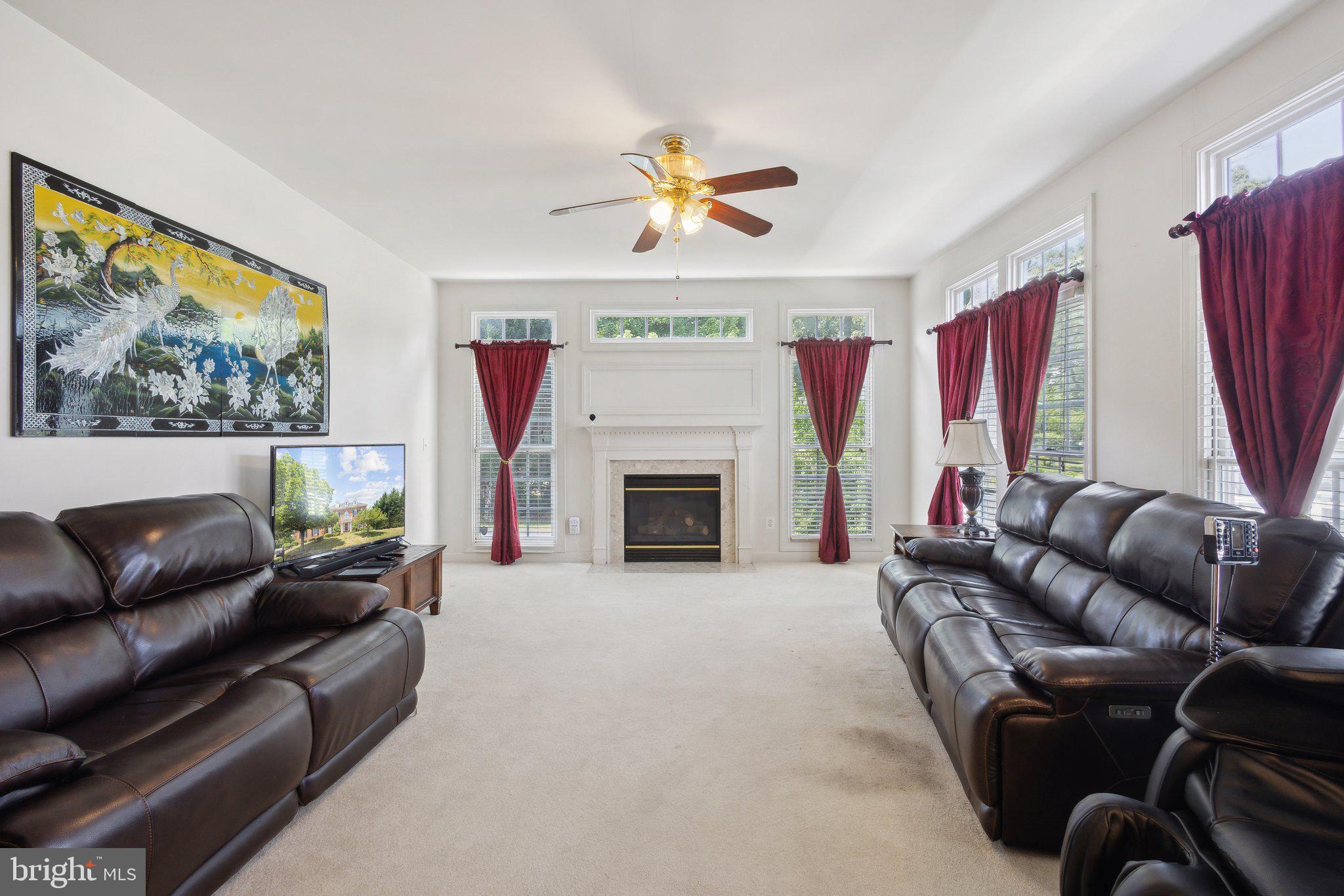 7102 Clarkson Drive Springfield, VA 22150 - Photo 8 of 26 a living room with furniture a fireplace and a large window