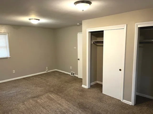 an empty room with closet and a window