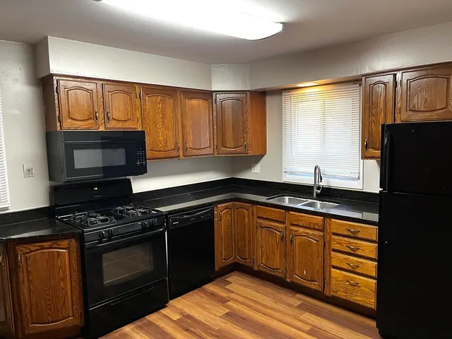 a kitchen with granite countertop cabinets stainless steel appliances and a sink
