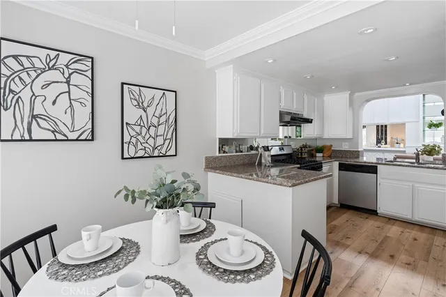 a kitchen with stainless steel appliances granite countertop a refrigerator a sink a stove and white cabinets