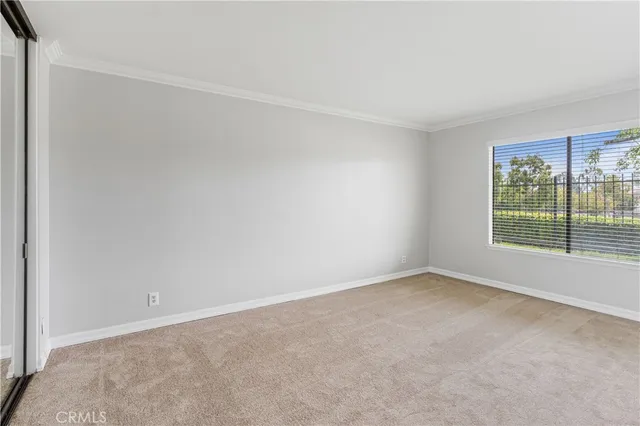 a view of an empty room with a cabinet and mirrors