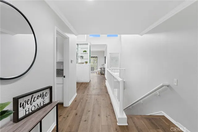 a view of a hallway with wooden floor and windows