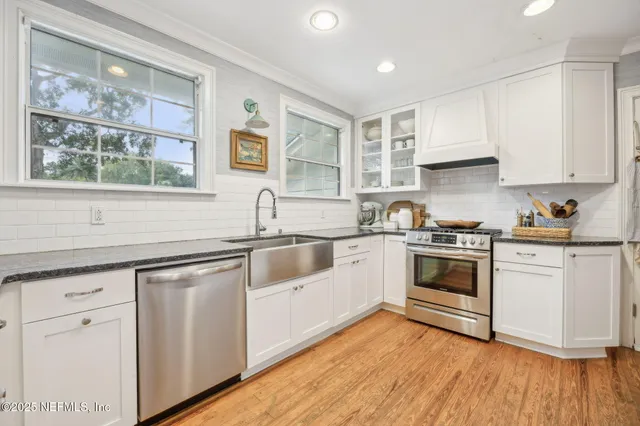 a kitchen with granite countertop white cabinets and white appliances
