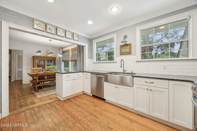 a kitchen with granite countertop a stove and white cabinets