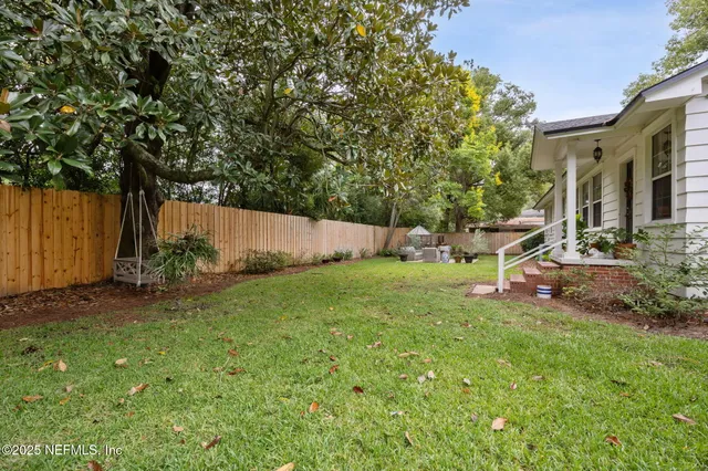 a view of a backyard with chair and potted plants