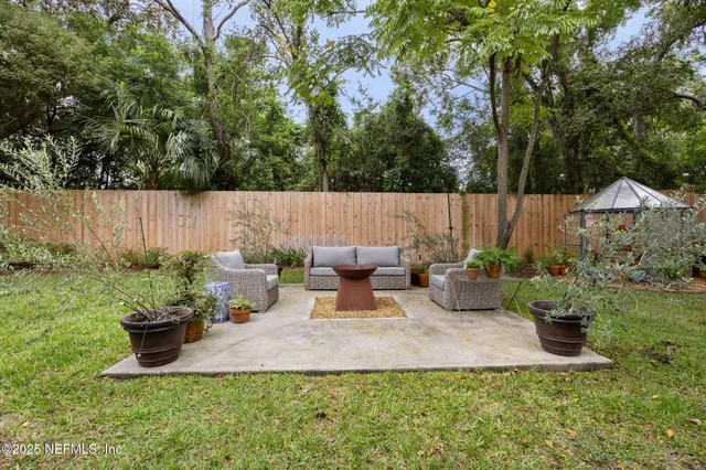 a view of a backyard with table and chairs and a fire pit