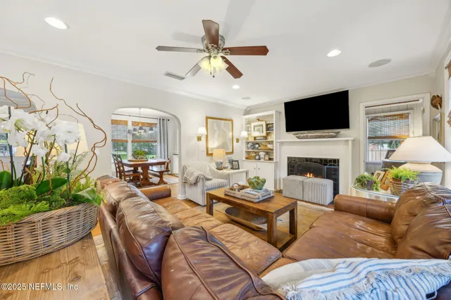 a living room with furniture a fireplace and a flat screen tv