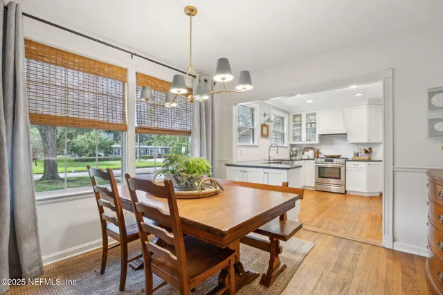 a dining room with furniture a chandelier and wooden floor