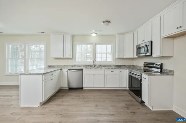 a room with a sink cabinets and wooden floor