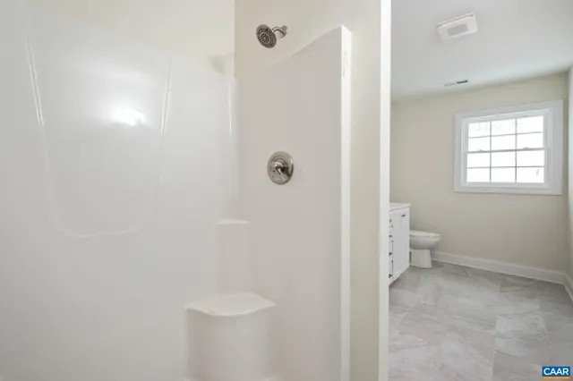 a view of a room with wooden floor and a ceiling fan