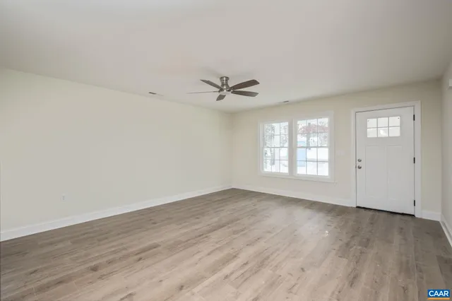 a view of empty room with wooden floor