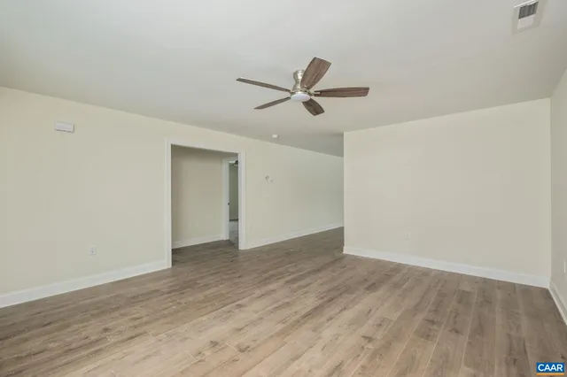 a large kitchen with cabinets wooden floor and a window