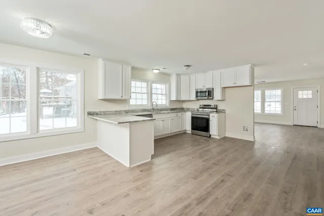a kitchen with granite countertop white cabinets and white appliances