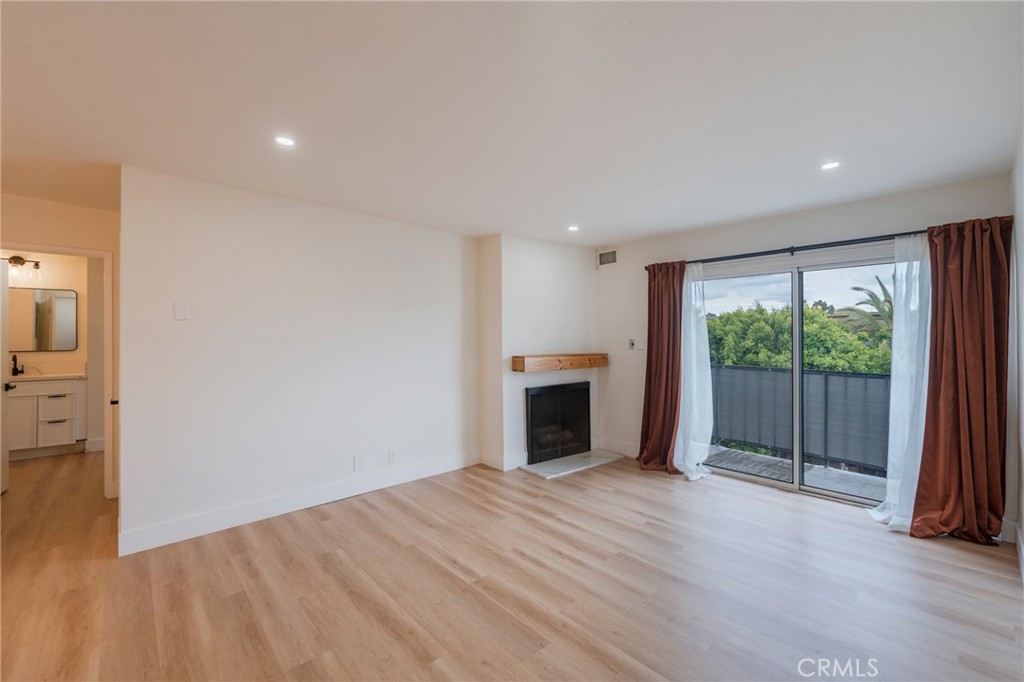 8163 Redlands Street, Unit 73 Playa del Rey, CA 90293 - Photo 3 of 23 a view of empty room with wooden floor and fireplace