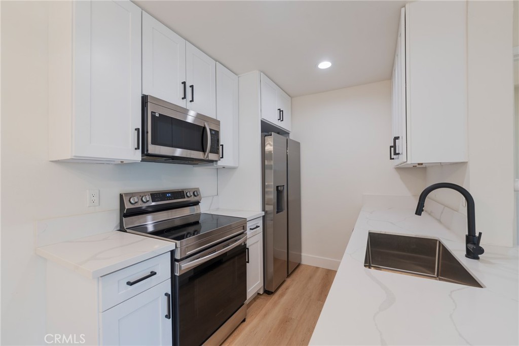 8163 Redlands Street, Unit 73 Playa del Rey, CA 90293 - Photo 6 of 23 a kitchen with stainless steel appliances a stove a sink a microwave and cabinets