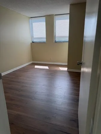 an empty room with wooden floor and sink