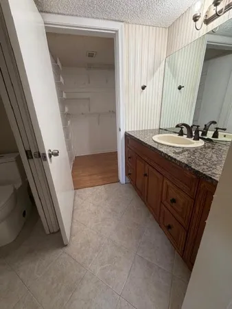 a bathroom with a granite countertop sink a mirror and a shower