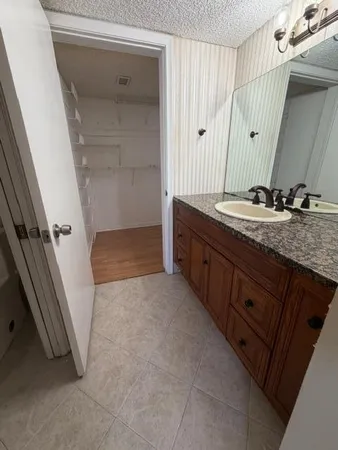 a bathroom with a granite countertop sink a mirror and a shower