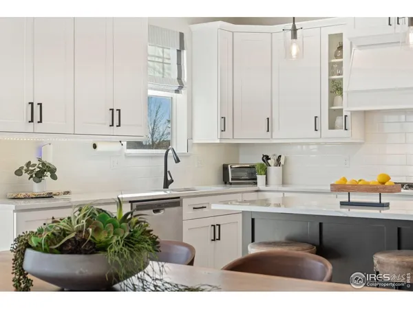 a kitchen with stainless steel appliances kitchen island granite countertop a sink a stove white cabinets and a granite counter tops