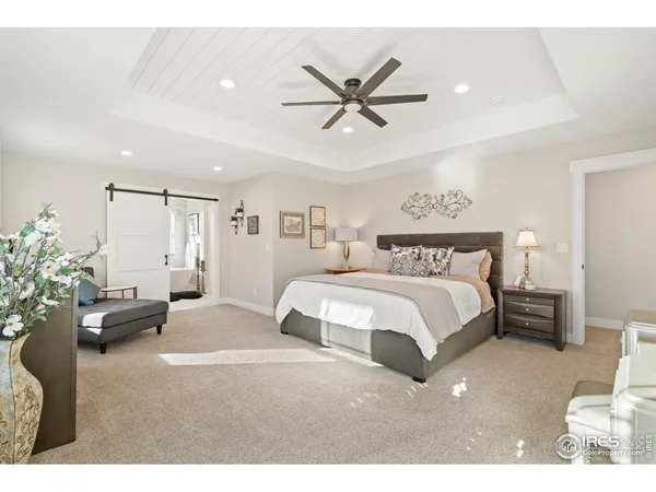 a spacious bedroom with a bed a couch and a potted plant