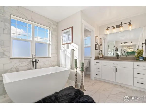a bathroom with a sink tub double vanity and mirror