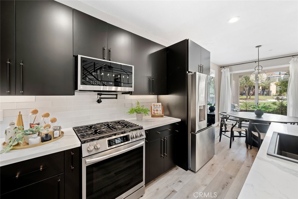 1177 Spring Azure Way, Unit 55 Nipomo, CA 93444 - Photo 11 of 75 a kitchen with stainless steel appliances a stove a refrigerator a sink a stove and island with wooden floor
