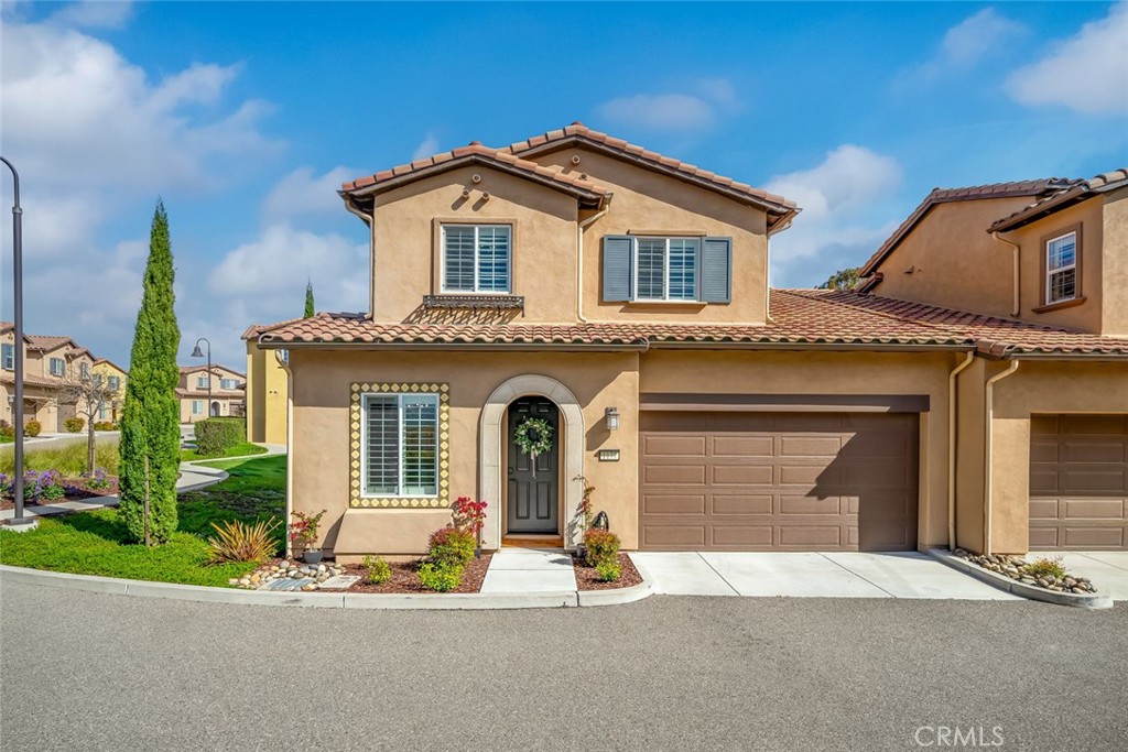 1177 Spring Azure Way, Unit 55 Nipomo, CA 93444 - Photo 2 of 75 a front view of a house with a yard and garage