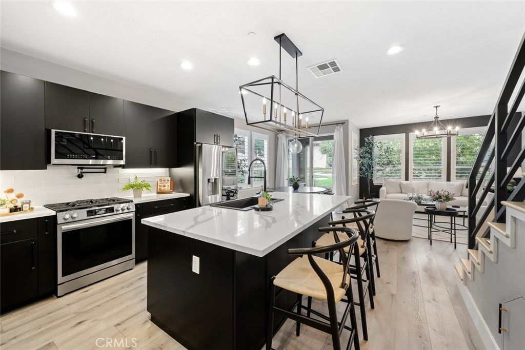 1177 Spring Azure Way, Unit 55 Nipomo, CA 93444 - Photo 4 of 75 a kitchen with stainless steel appliances granite countertop a stove a sink dishwasher a dining table and chairs with wooden floor