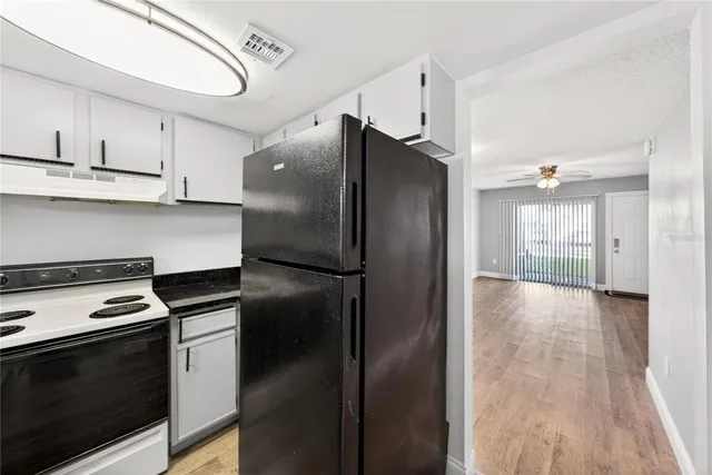 a kitchen with stainless steel appliances granite countertop a refrigerator a stove and a microwave