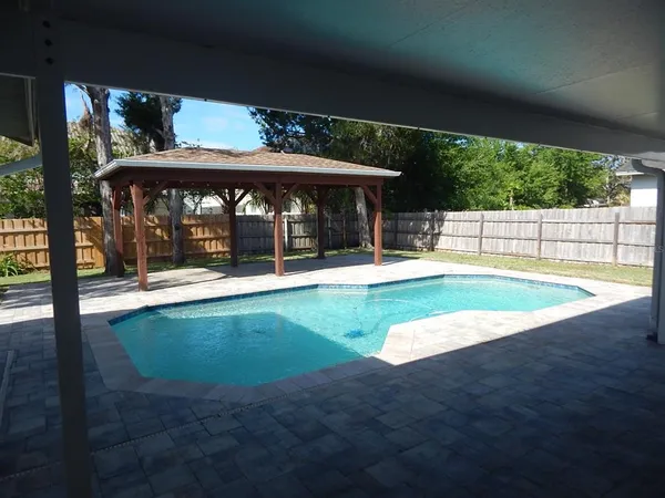 a view of a patio with a table chairs and a backyard