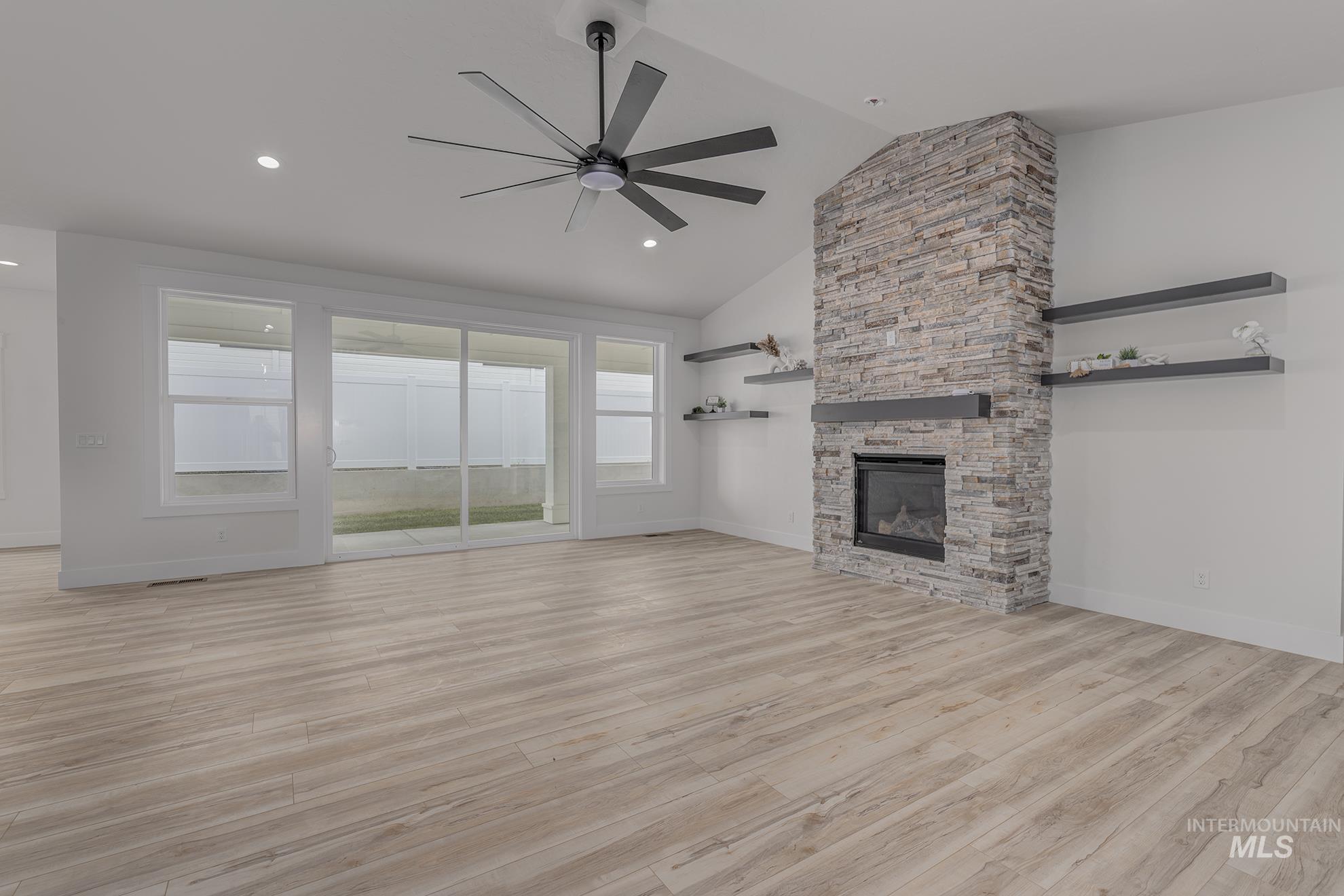 2810 Cypress Point Payette, ID 83661 - Photo 11 of 46 Unfurnished living room with light wood finished floors, a fireplace, ceiling fan, high vaulted ceiling, and recessed lighting