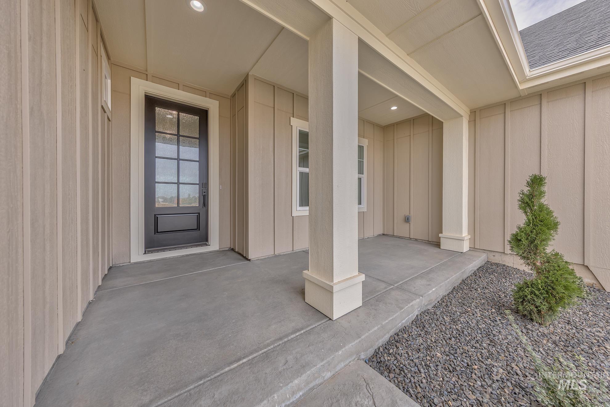 2810 Cypress Point Payette, ID 83661 - Photo 13 of 46 Doorway to property featuring board and batten siding, a shingled roof, and a porch