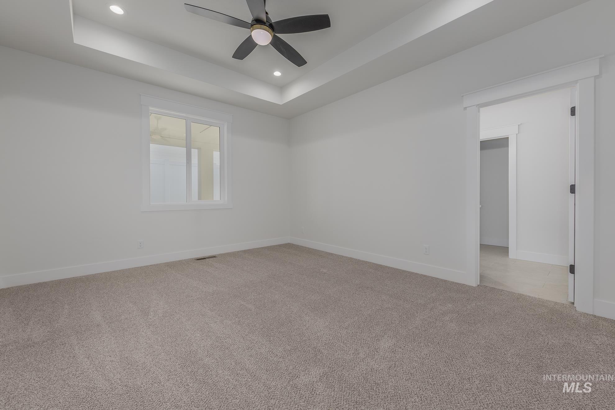 2810 Cypress Point Payette, ID 83661 - Photo 15 of 46 Spare room with a tray ceiling, light carpet, ceiling fan, and recessed lighting