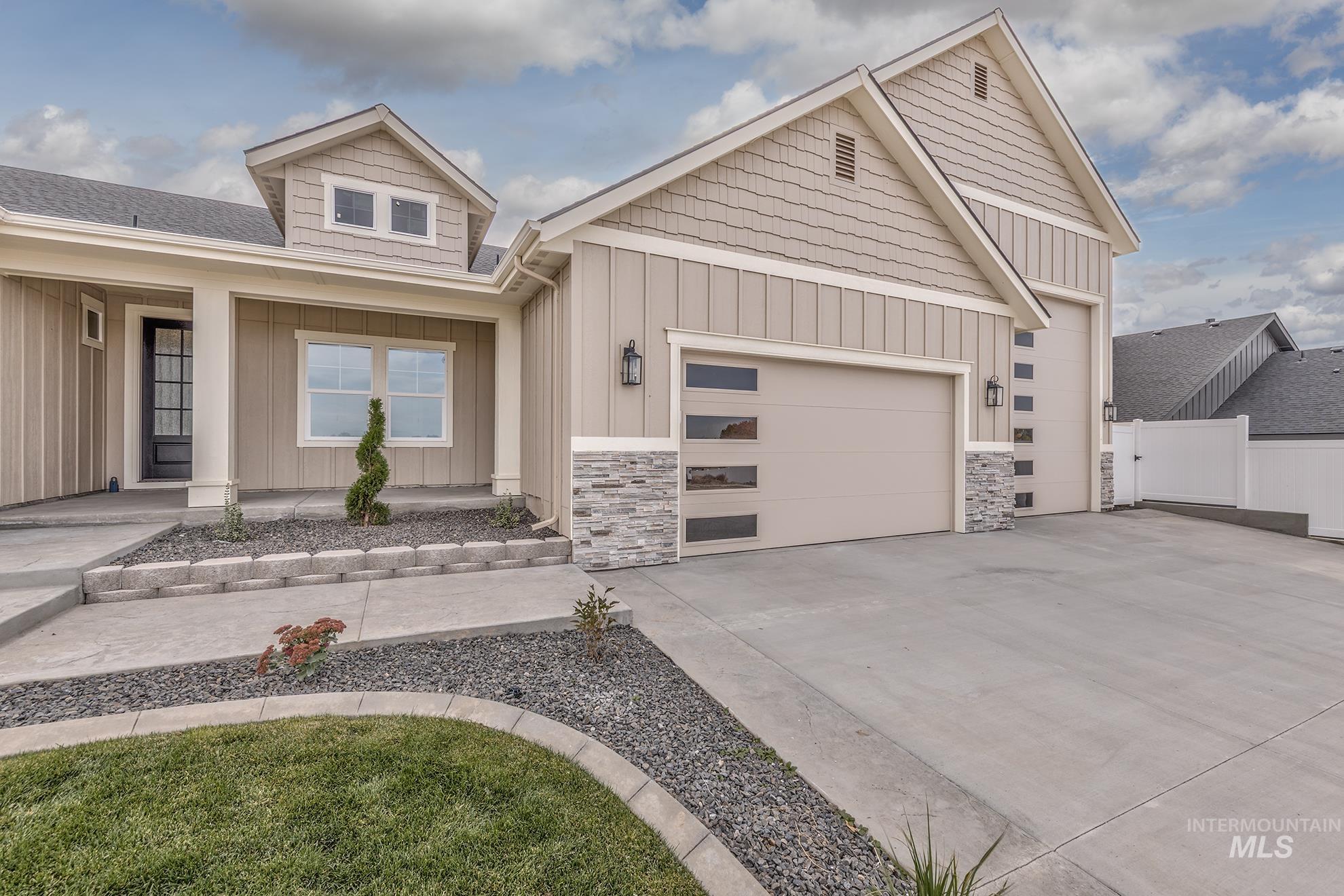2810 Cypress Point Payette, ID 83661 - Photo 41 of 46 View of front facade featuring board and batten siding, driveway, a porch, a garage, and stone siding