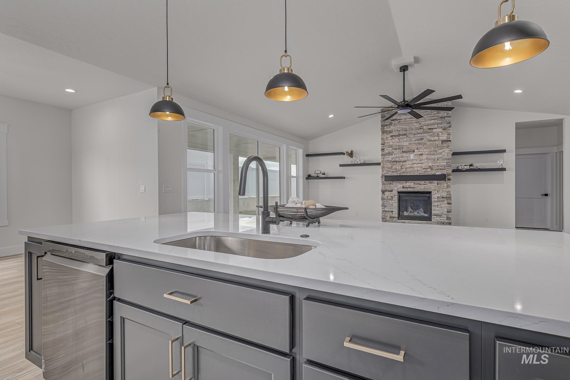 2810 Cypress Point Payette, ID 83661 - Photo 46 of 46 Kitchen featuring gray cabinetry, light stone countertops, open floor plan, decorative light fixtures, and lofted ceiling