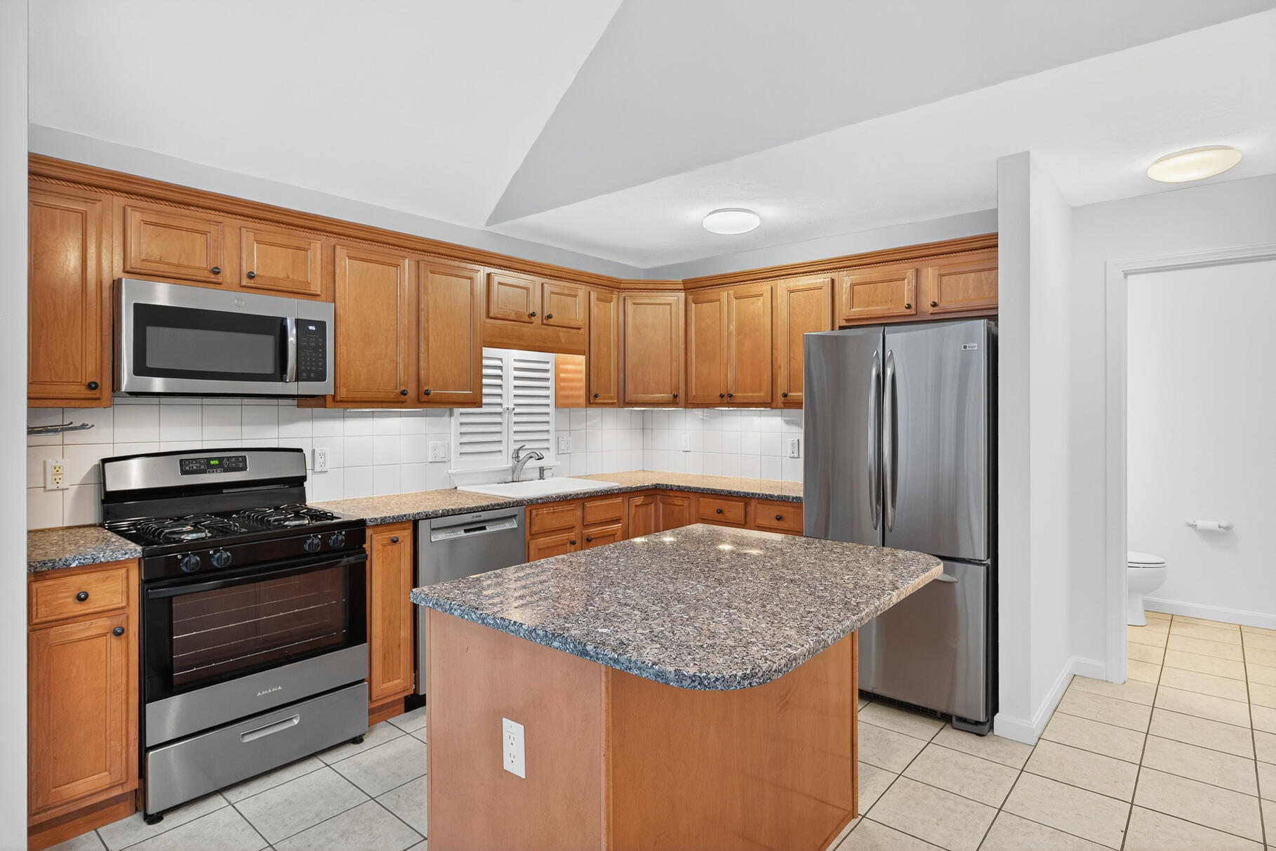 16 Gold Leaf Lane, Unit 16 Mashpee, MA 02649 - Photo 13 of 51 a kitchen with stainless steel appliances granite countertop a stove top oven a refrigerator a sink and dishwasher with wooden floor