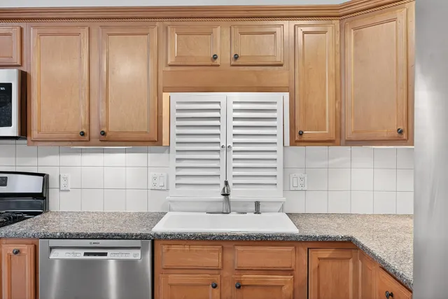 a kitchen with granite countertop cabinets sink and window