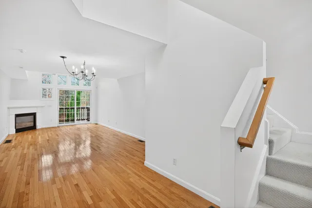 a view of empty room with fireplace and wooden floor