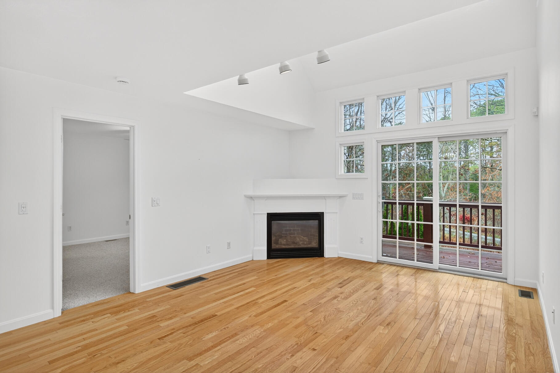 16 Gold Leaf Lane, Unit 16 Mashpee, MA 02649 - Photo 9 of 51 a view of empty room with wooden floor and fireplace