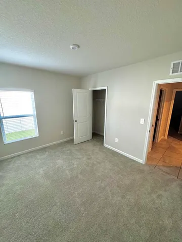 an empty room with closet and windows