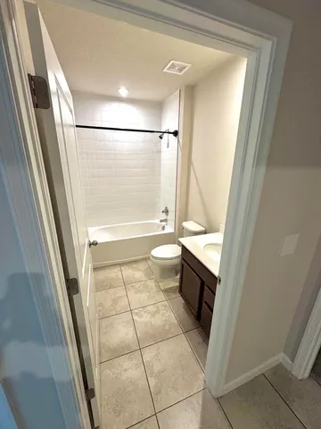 a bathroom with a granite countertop shower and a toilet