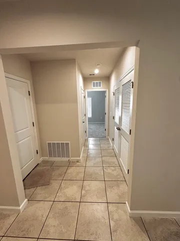 an empty room with a bathroom and a window